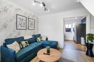 a living room with a blue couch and a table at BRAND NEW - Delightful Abode in London - Garden in London