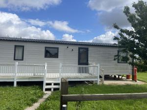 ein Haus mit zwei Bänken davor in der Unterkunft Orchard View Caravan in Boston