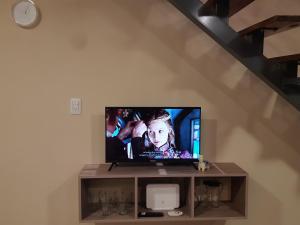telewizor z płaskim ekranem siedzący na półce w obiekcie Duplex Mi Lar w mieście Termas de Río Hondo