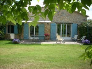 una casa con sillas y una mesa en el patio en Domaine Le Rolant, en Montaut