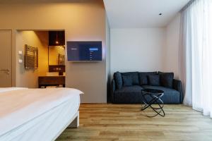 ein Hotelzimmer mit einem Sofa und einem Bett in der Unterkunft WUD hotel in Ljubljana