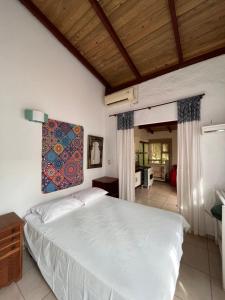 Casa Mico Leão Dourado في بومبينهاس: غرفة نوم بسرير ودهان على الحائط