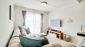 a living room with a couch and a window at Urban Oasis - near OR Tambo Airport with UPS back up in Witfield