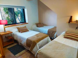 1 Schlafzimmer mit 2 Betten und einem Fenster in der Unterkunft Tres Vistas in San Carlos de Bariloche