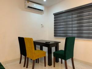 a dining room with a table and two chairs at Charming & Cozy 1-BDR Apt - Mini Flat - 247 Power, Kitchen, Wi-Fi, DSTV, Netflix, 5 mins from the Airports in Ikeja
