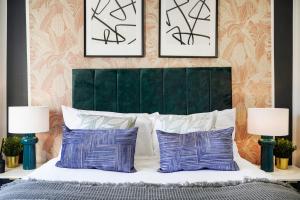 a bedroom with a green headboard and two framed pictures at BRAND NEW - Delightful Abode in London - Garden in London