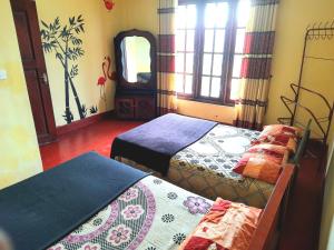 a room with two beds and a mirror at Green Villa in Nuwara Eliya