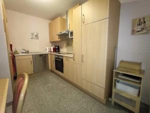 a small kitchen with wooden cabinets and a stove at Ferienwohnung / Ferienhaus Homburg in Homburg