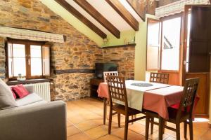 a dining room with a table and a couch at Apartamentos Turisticos A Estacion in A Pontenova