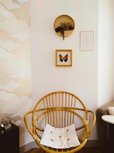 une chaise dans une pièce avec une horloge sur le mur dans l'établissement Les Vitraux de Saint Rémi, à Dieppe
