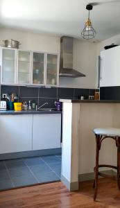 a kitchen with white cabinets and a table at Les Vitraux de Saint Rémi in Dieppe