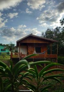 uma pequena cabana com uma rede em frente em LUZ AMAZÔNIA LODGE em Iranduba