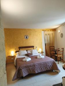 een slaapkamer met een groot bed en 2 handdoeken bij MEITHRAS Holiday Homes in Agrigento