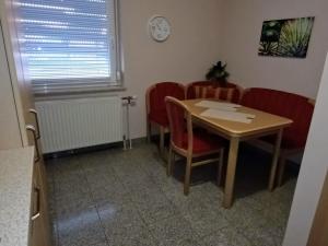 ein Esszimmer mit einem Tisch und roten Stühlen in der Unterkunft Ferienwohnung / Ferienhaus Homburg in Homburg