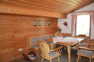 ein hölzernes Esszimmer mit einem Tisch und Stühlen in der Unterkunft Gästehaus Aicher in Inzell