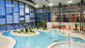 a large building with a large swimming pool at The Jangle Hotel - Paris - Charles de Gaulle - Airport in Le Mesnil-Amelot