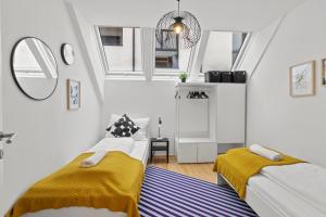 a bedroom with two beds and a mirror at Modern Haven - Near Klinik Floridsdorf in Vienna