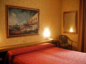 プレガンツィオールにあるHotel Al Soleのベッドルーム1室(ベッド1台付)が備わります。壁には絵画が飾られています。