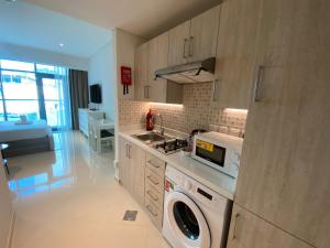 a kitchen with a washer and dryer in it at Black and white flower oasis in Seven Palm in Dubai