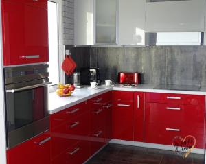 a red kitchen with white counters and red cabinets at La pépite d'amour in Sainte-Anastasie-sur-Issole