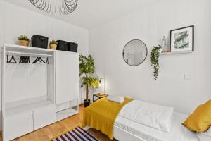 a white bedroom with a bed and a mirror at Modern Haven - Near Klinik Floridsdorf in Vienna