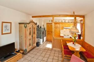 een woonkamer met een tafel en een keuken bij Ferienwohnungen im Feriendorf Sonnenhang im Allgäu in Missen-Wilhams