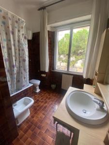 bagno con lavandino, servizi igienici e finestra di UrbinHouse1 ad Ancona