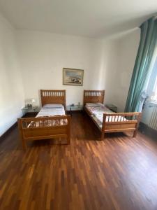2 Betten in einem Zimmer mit Holzböden in der Unterkunft UrbinHouse1 in Ancona