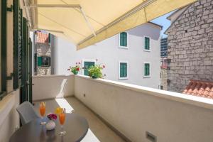 een balkon met een tafel en wijnglazen erop bij Balatura The Fine Bed&Breakfast Split in Split