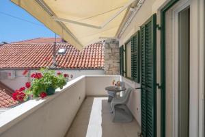 a balcony with a table and flowers on a building at Balatura The Fine Bed&Breakfast Split in Split