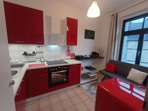 a kitchen with red cabinets and a red oven at Ferienwohnung Stefan Heym am Kaßberg in Chemnitz +11 photos