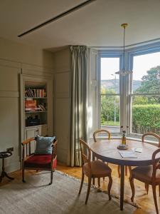 sala de estar con mesa, sillas y ventana en Jameswood Villa, en Sandbank