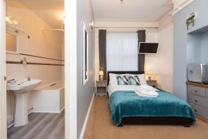 a bedroom with a bed and a sink at Coastal One Bedroom Apartment Free Parking in Great Yarmouth