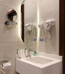 W łazience znajduje się umywalka i lustro. w obiekcie جوهرة دومة الجندل للشقق المخدومة Jawharat Dumat Serviced Apartments w mieście Dawmat al Jandal