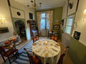 een eetkamer met een tafel en stoelen en een kamer met een eetkamer bij La Grenouille Noire in Marcillat-en-Combraille