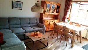 een woonkamer met een bank en een tafel en stoelen bij Ferienwohnung Enzian 2 im Feriendorf Sonnenhang im Allgäu in Missen-Wilhams