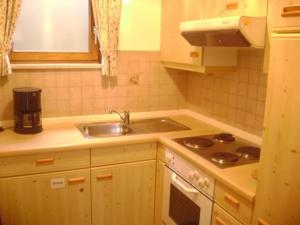 a kitchen with a sink and a stove at Ferienwohnung Enzian 2 im Feriendorf Sonnenhang im Allgäu in Missen-Wilhams +59 photos