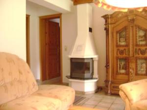a living room with a fireplace and a couch and a stove at Ferienwohnung Enzian 1 im Feriendorf Sonnenhang im Allgäu in Missen-Wilhams +58 photos