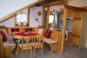 uma cozinha e sala de jantar com mesa e cadeiras em Ferienwohnung Sonnentau im Feriendorf Sonnenhang im Allgäu em Missen-Wilhams