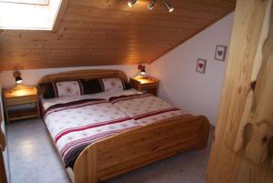 um quarto com uma cama de madeira num sótão em Ferienwohnung Sonnentau im Feriendorf Sonnenhang im Allgäu em Missen-Wilhams