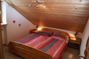 uma cama num quarto com tecto em madeira em Ferienwohnung Sonnentau im Feriendorf Sonnenhang im Allgäu em Missen-Wilhams