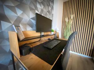 a desk with a computer monitor and a keyboard at Design Immo Ferienwohnung Rhein-Main Rodgau in Rodgau