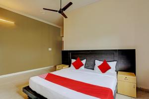 um quarto com uma cama grande e almofadas vermelhas em OYO Flagship Hotel Jagdambey Residency em Noida