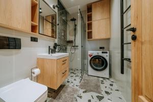 y baño con lavadora y ducha. en Krupówki 25A Górski Loft by Homeprime, en Zakopane