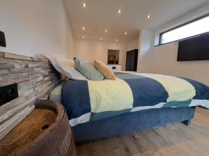 een slaapkamer met een groot bed en een stenen muur bij AMIKALEMENT VÔTRE - Gîte 2 personnes in La-Roche-en-Ardenne
