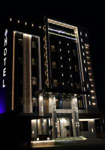 a large building with lights on it at night at جوهرة دومة الجندل للشقق المخدومة Jawharat Dumat Serviced Apartments in Dawmat al Jandal