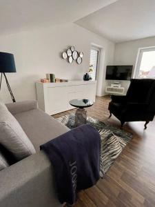 ein Wohnzimmer mit einem Sofa und einem TV in der Unterkunft Apartment Living in Schwabach