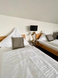 1 dormitorio con 2 camas y mesa con lámpara en Apartment Living en Schwabach
