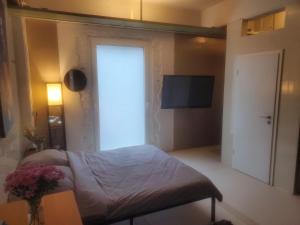 ein Zimmer mit einem Bett und einer Tür mit einem Fernseher in der Unterkunft SPA industrial Loft in einem ehemaligen Umspannwerk in Essen