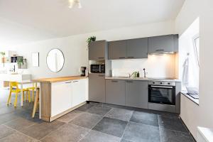 a kitchen with stainless steel appliances and a table at Le Gîtel in Spa